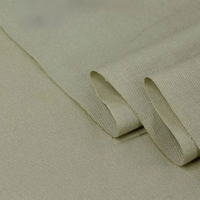 A close-up of Longan Craft’s Twill Cotton Lyocell Fabric By The Yard in light beige, showing its subtle diagonal weave and overlapping folded edges—ideal comfy, breathable textile for shirts.