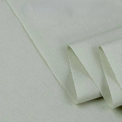 A close-up of folded, light gray Longan Craft Twill Cotton Lyocell Fabric By The Yard, featuring a subtle diagonal weave—this comfy and breathable solid color textile is ideal for shirts.