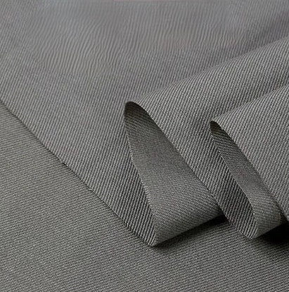 A close-up of Longan Craft's Twill Cotton Lyocell Fabric By The Yard in light gray, showcasing its subtle diagonal weave and folded edge—an eco-friendly, comfy, and breathable textile ideal for shirts.