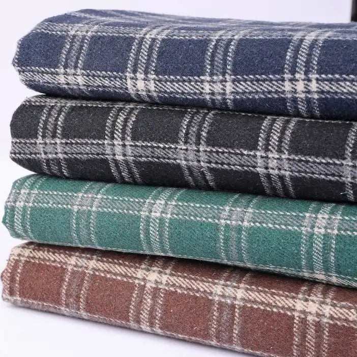 Four folded pieces of the Longan Craft Vintage Checked Mammoth Flannel Fabric by the Yard—available in blue, dark gray, green, and brown, each with a classic white checkered gingham pattern—are stacked neatly against a white background. This thick cotton flannelette fabric offers a cozy and durable feel that is perfect for fall sewing projects.