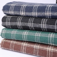 Four folded pieces of the Longan Craft Vintage Checked Mammoth Flannel Fabric by the Yard—available in blue, dark gray, green, and brown, each with a classic white checkered gingham pattern—are stacked neatly against a white background. This thick cotton flannelette fabric offers a cozy and durable feel that is perfect for fall sewing projects.