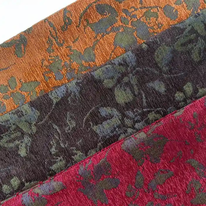 Three folded pieces of Longan Craft's Vintage Flower Pattern Chenille Fabric by the yard in orange, dark gray, and red display a subtle floral jacquard design—ideal for home decor and apparel projects.