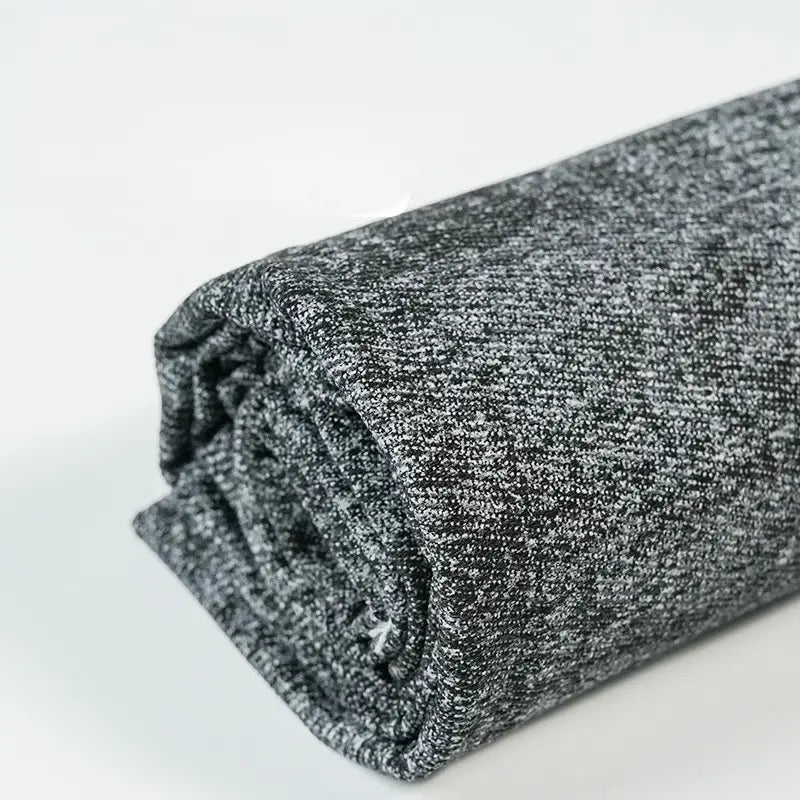 A close-up of Longan Craft's Washed Denim Fabric By The Yard shows the detailed weave of this premium, vintage cotton denim textile—perfect for jeans—rolled up on a white surface.