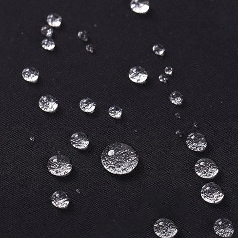 Small water droplets on Longan Craft's Waterproof Gabardine Fabric By The Yard show the water-resistant quality of this solid color twill gabardine textile, perfect for durable workwear and versatile outdoor use.