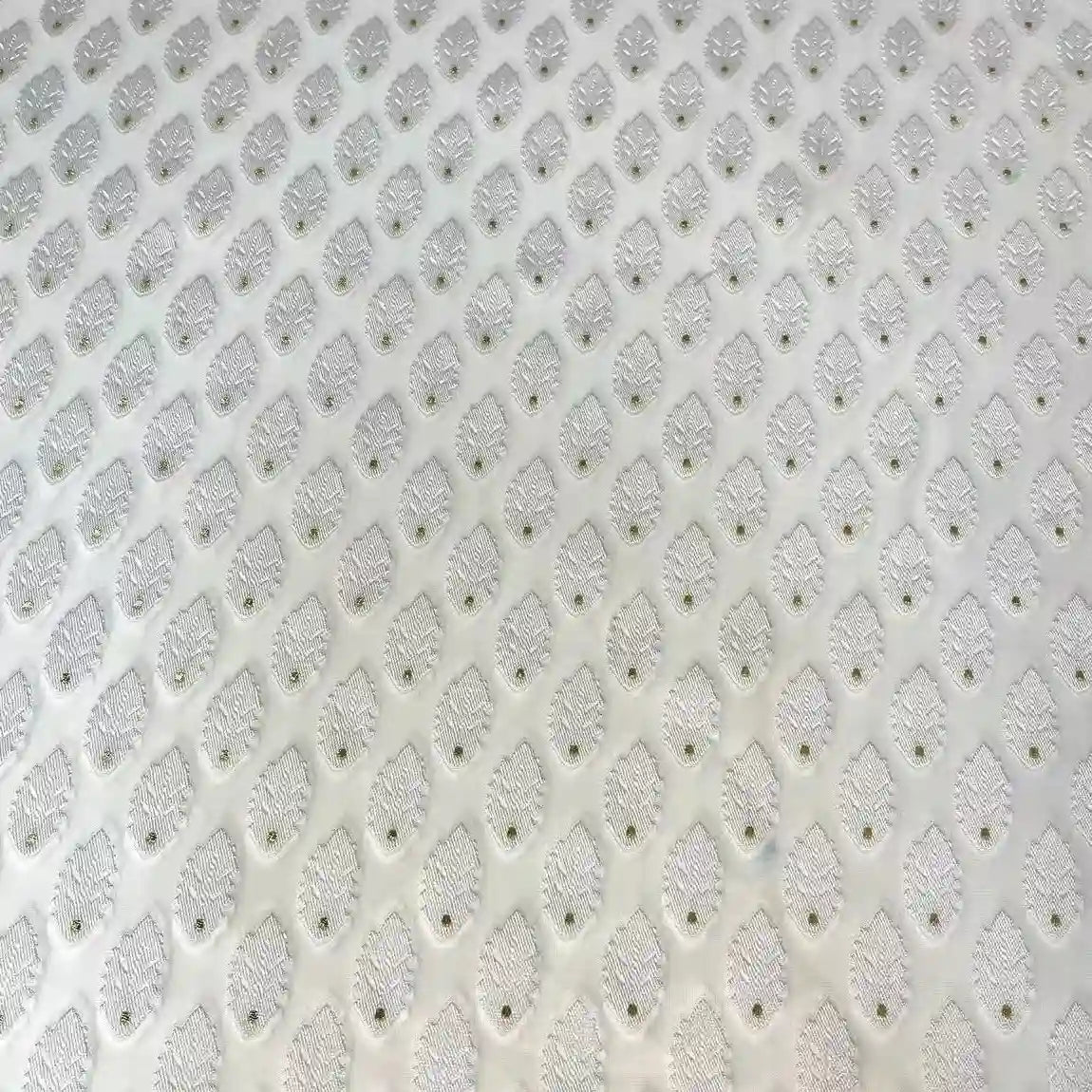 A close-up of Longan Craft’s White Leaf Pattern Organza Fabric by the yard shows a light, slightly reflective jacquard with raised oval bumps and tiny center holes, ideal for clothing and featuring a botanical-inspired design.