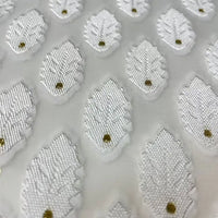 Close-up of Longan Craft’s White Leaf Pattern Organza Fabric by the yard, a sheer botanical jacquard with raised embroidered leaves and gold dots in a geometric layout—ideal organza material for clothing.
