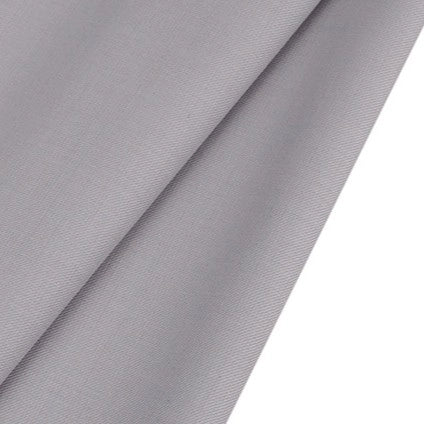 A close-up of Longan raft Worsted Wool Gabardine Fabric By The Yard shows its smooth, slightly textured light gray poly wool blended twill surface, folded neatly—perfect durable material for tailored suits.