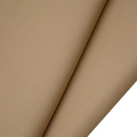 A close-up of Longan raft Worsted Wool Gabardine fabric by the yard shows its smooth light brown poly-wool twill texture, with two overlapping folds forming diagonal lines—ideal durable material for tailored suits.