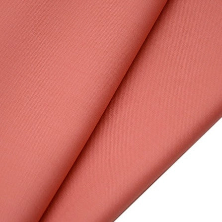Close-up of two overlapping pieces of Longan raft Worsted Wool Gabardine Fabric, a coral pink poly wool blended twill. The material is smooth, slightly textured, and folded to highlight its soft, even finish—ideal for tailored suits.