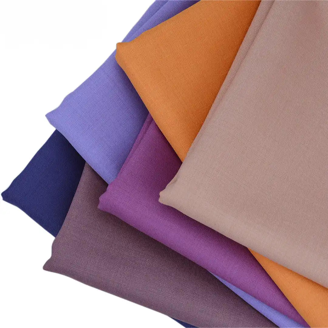 Five pieces of Longan raft Worsted Wool Gabardine Fabric By The Yard in dark blue, lavender, purple, orange, and beige are fanned out on a white background. This colorful poly wool blend is ideal for tailored suits.