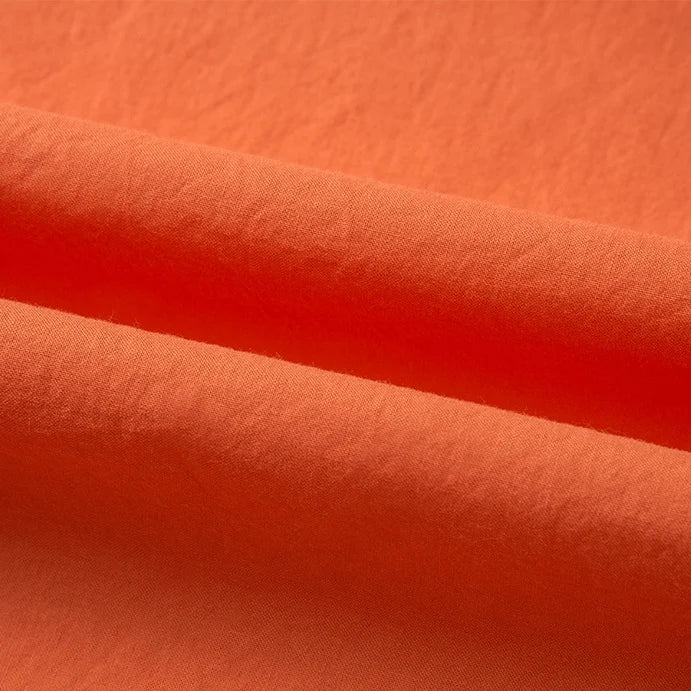 A close-up of Longan Craft's Woven Lawn Fabric By The Yard reveals its smooth, soft multicolor cotton lawn texture and gentle shadows—ideal as a lining or material for sewing projects.
