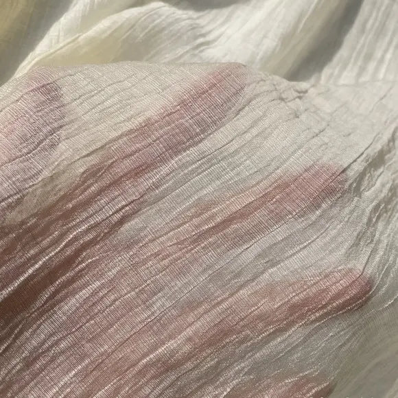 A hand is seen beneath Longan Craft’s Wrinkled Lyocell Fabric By The Yard, its fingers forming a subtle outline through the sheer, textured, sustainable lyocell material—perfect for breathable tops.