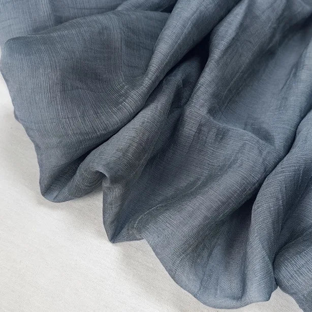 A close-up of Longan Craft’s Wrinkled Lyocell Fabric By The Yard showcases its soft, lightweight texture and breathable, sustainable solid color material—ideal for making tops.