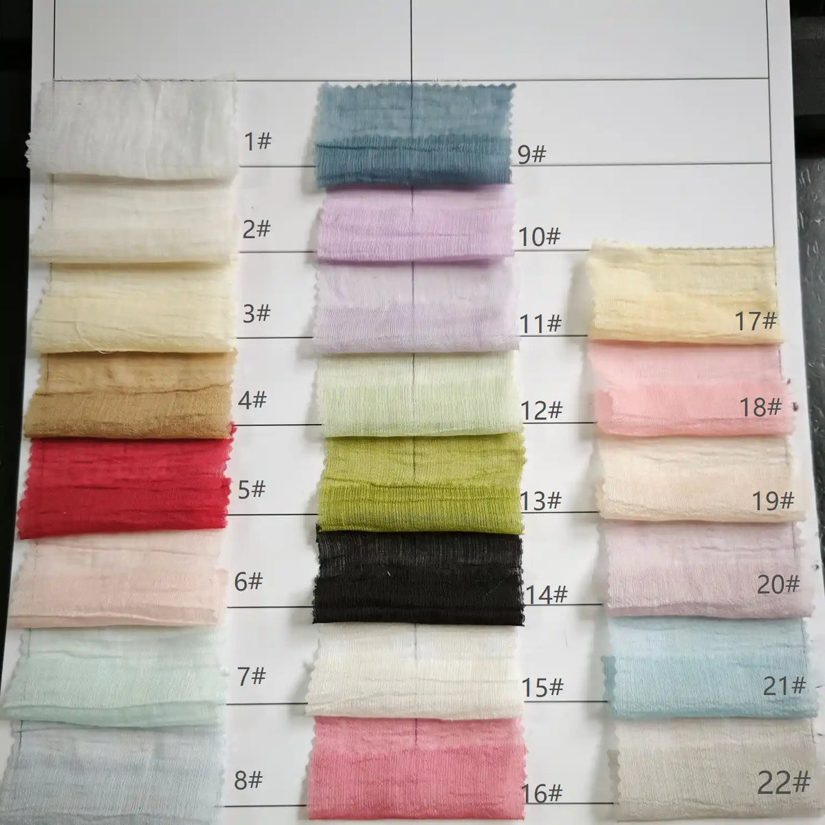 A fabric swatch chart for Longan Craft's Wrinkled Lyocell Fabric By The Yard shows 22 numbered, solid-colored sustainable samples in four columns on a white background, perfect for choosing breathable lyocell textile for tops.