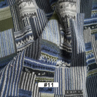 A close-up of Longon Craft’s Christmas Polar Fleece Fabric By The Yard, a thick, double-sided polyester with a blue, gray, white, and green patchwork print. The bottom features a white label marked #11 in black.