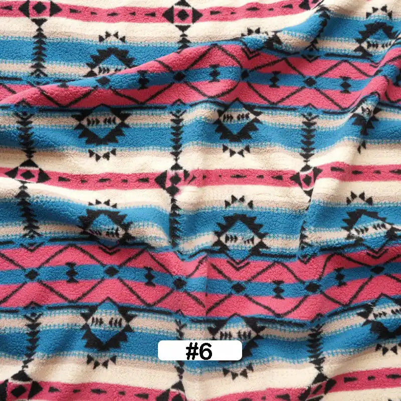 Longon Craft Christmas Polar Fleece Fabric By The Yard features a vibrant geometric tribal pattern in pink, blue, black, and white. This thick, double-sided polyester fleece comes slightly wrinkled and is labeled #6 in black text on white.