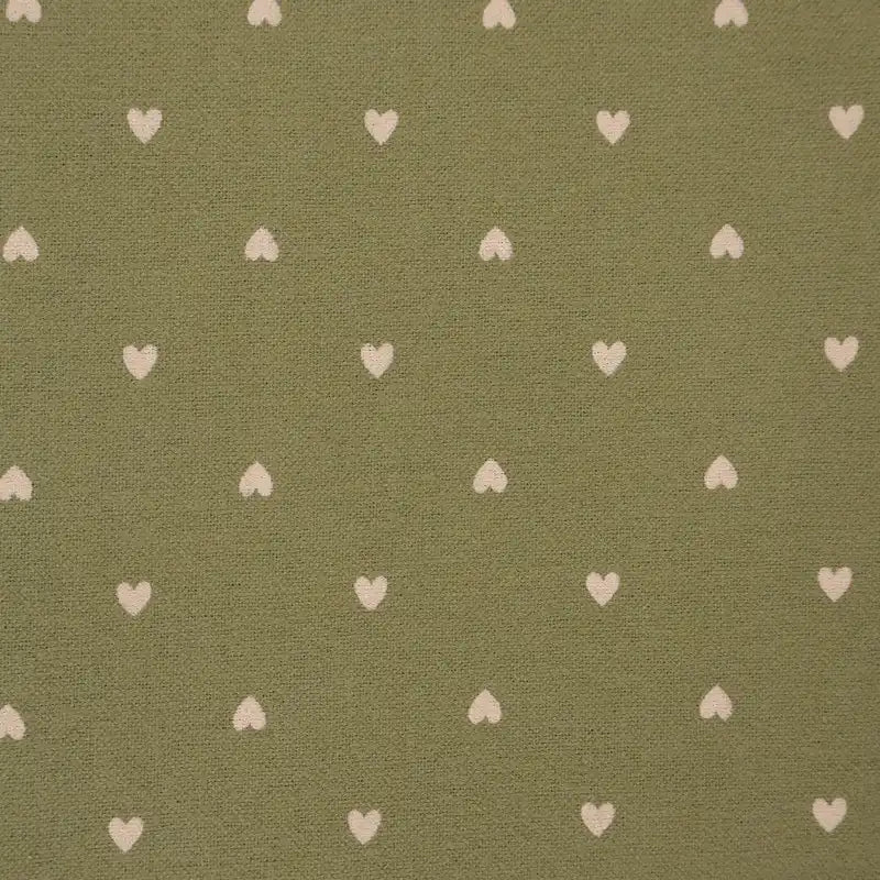 Pattern of small white hearts on a green fabric background