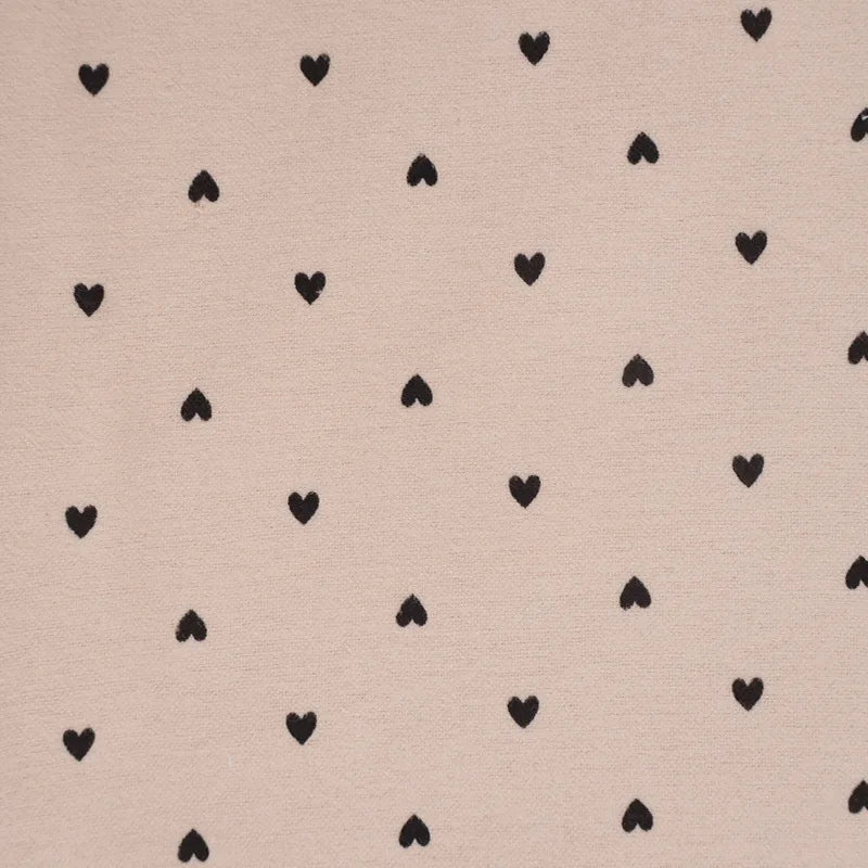 Pattern of black hearts on a beige background