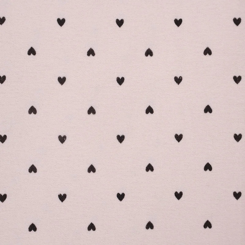 Pattern of black hearts on a light pink background