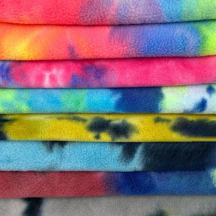 A close-up of Longon Craft’s Double Sided Polar Fleece Fabric By The Yard shows its soft, textured surface and vibrant tie dye watercolor print in pink, yellow, blue, green, and gray—ideal for clothing sewing projects.