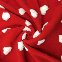 A close-up of Longon Craft's Heart Polar Fleece Fabric By The Yard, a soft red polyester fleece with 3D white heart patterns, twisted into a spiral pattern at the center.