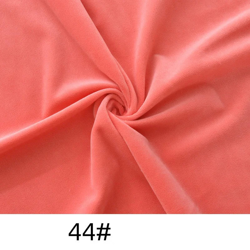 A close-up of Longon Craft’s Minky Fabric By The Yard in a coral pink shade, twisted to show its thick, plush texture and drape. “44#” is displayed below the soft solid color cuddle material for sewing and crafts.
