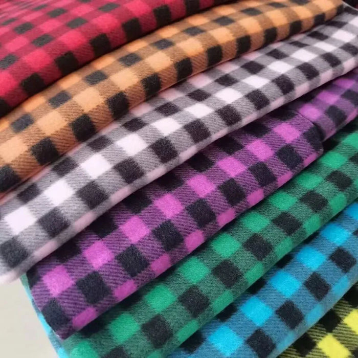 Neatly folded stacks of Longon Craft Plaid Polar Fleece Fabric by the Yard, 100% polyester, in vibrant checkered patterns—orange, brown, white, pink, purple, green, and blue—perfect for DIY sewing projects and cozy displays.