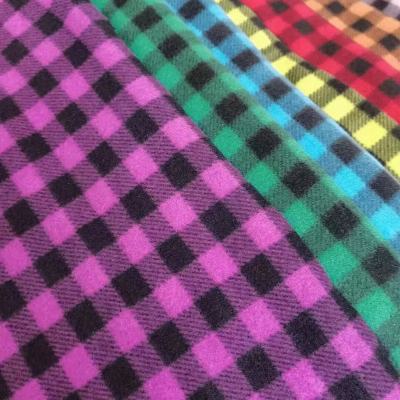Close-up of Longon Craft Plaid Polar Fleece Fabric By The Yard—100% polyester with vibrant diagonal checks in purple, green, blue, yellow, and red. Perfect for cozy DIY sewing projects; available as patterned printed polar fleece.
