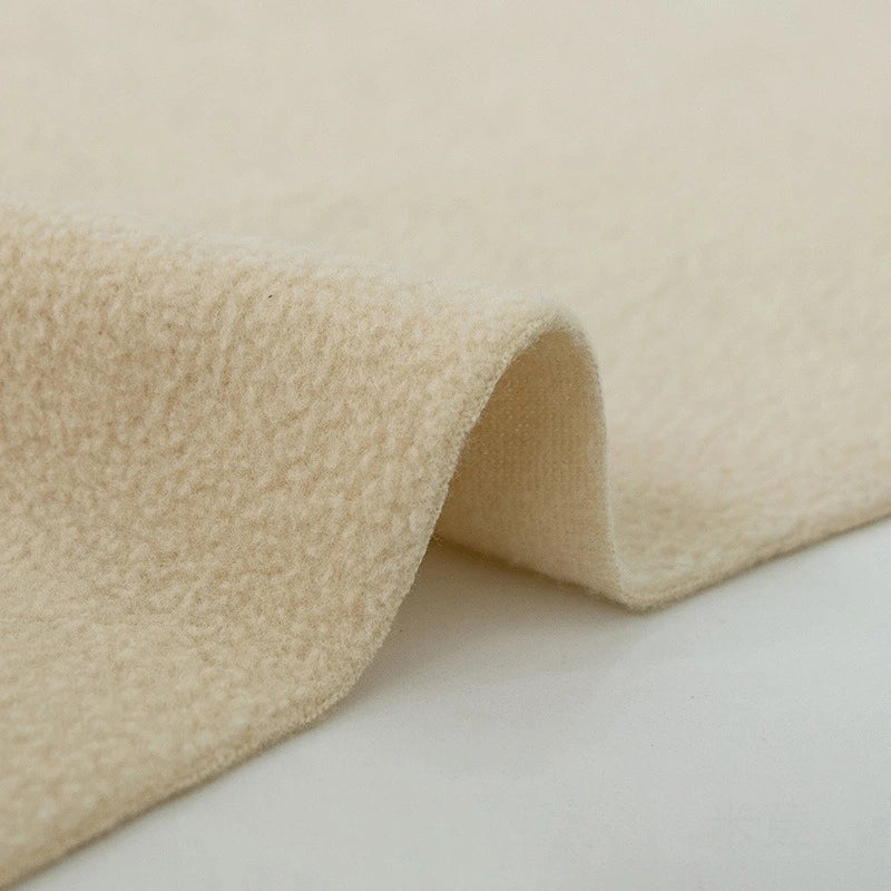 A close-up of Longon Craft's Plain Polar Fleece Fabric by the yard shows its thick, anti-pill beige polyester with a soft, textured surface and gentle folds. The background is plain white.