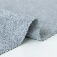 A close-up of Longon Craft's Plain Polar Fleece Fabric By The Yard shows its soft, light gray, thick anti-pill polyester with a smooth surface—perfect for outdoor jackets and thermal blankets. This stretch polar fleece is ideal for sewing projects.