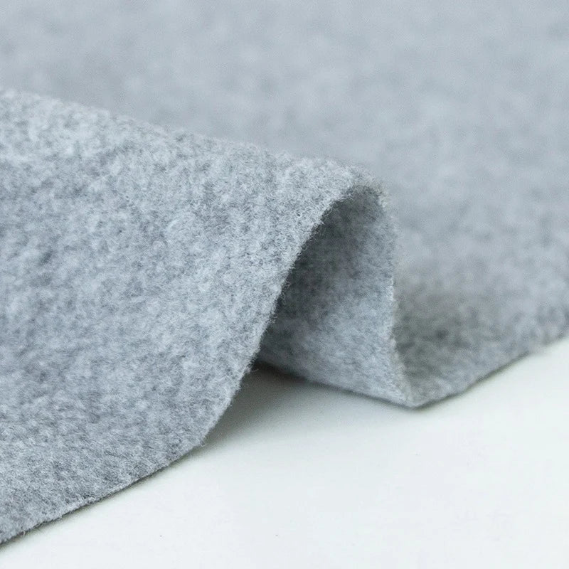 A close-up of Longon Craft's Plain Polar Fleece Fabric By The Yard shows its soft, light gray, thick anti-pill polyester with a smooth surface—perfect for outdoor jackets and thermal blankets. This stretch polar fleece is ideal for sewing projects.