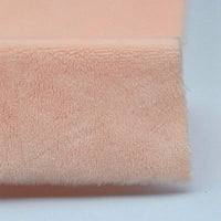 A close-up of Longon Craft Plush Minky Fabric By The Yard in a peach solid color, crafted from ultra-soft 5mm polyester minky material, ideal for plushies and sewing crafts, shown folded against a plain background.