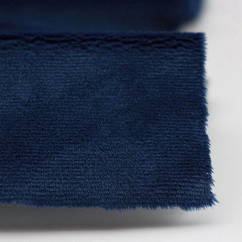 Close-up of Longon Craft Plush Minky Fabric by the Yard, a dark blue 5mm ultra-soft polyester material with a slightly frayed edge, shown on a light background; perfect for plushies, sewing, and crafts.