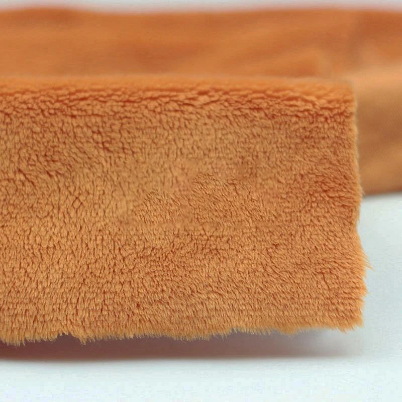 Close-up of Longon Craft Plush Minky Fabric By The Yard (5mm soft polyester, solid orange) on a white surface—ideal for baby blankets, plushies, and craft sewing projects.