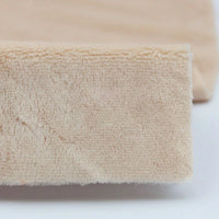 Close-up of beige Plush Minky Fabric by the yard from Longon Craft, made of ultra-soft 5mm polyester, used as a fitted sheet covering a mattress corner—ideal for plushies sewing and crafts.