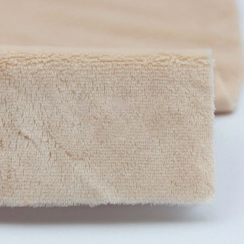 Close-up of beige Plush Minky Fabric by the yard from Longon Craft, made of ultra-soft 5mm polyester, used as a fitted sheet covering a mattress corner—ideal for plushies sewing and crafts.