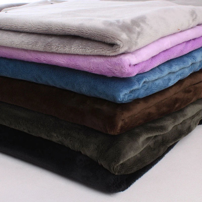 A neatly stacked pile of Longon Craft Plush Minky Fabric by the yard in solid colors—grey, purple, blue, brown, green, and black—features 5mm ultra-soft polyester ideal for plushies, sewing, and crafts.