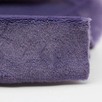 Close-up of Longon Craft’s Plush Minky Fabric By The Yard—a 5mm soft polyester solid color minky, perfect for plushies, sewing, and crafts—showing its purple, fuzzy texture on a white surface.