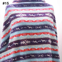 A person is wrapped in Longon Craft’s Printed Polar Fleece Fabric by the yard, featuring an ethnic leopard pattern. The soft polyester fleece is perfect for DIY crafts and sewing projects. The fabric label shows #15 in bold black text.