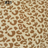 Close-up of Longon Craft’s Printed Polar Fleece Fabric By The Yard in a tan and light brown ethnic leopard pattern. The number #31 appears in black in the top left. Ideal polyester material for DIY craft and sewing projects.