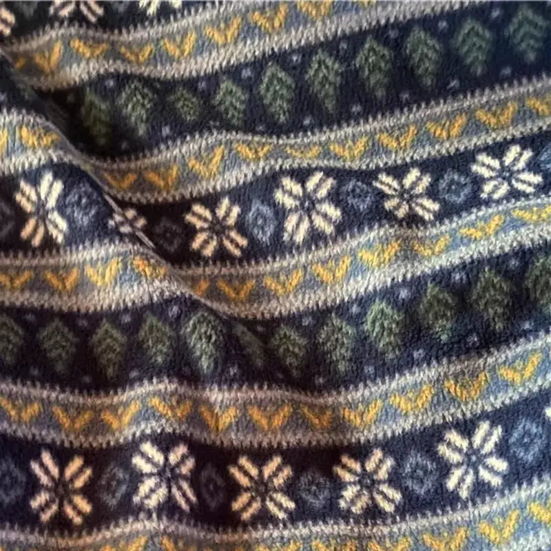 A close-up of Longon Craft's Snowflake Polar Fleece Fabric by the yard, featuring blue stripes with white snowflake and yellow geometric patterns—ideal for cozy DIY projects using this polyester sewing craft material.