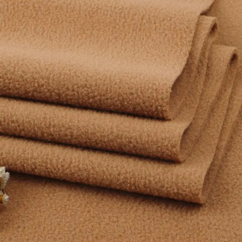 Three neatly folded pieces of Longon Craft Solid Polar Fleece Fabric By The Yard in soft brown, showing a smooth, slightly textured surface—ideal for cozy blankets, DIY sewing, crafts, or upholstery fabric projects.
