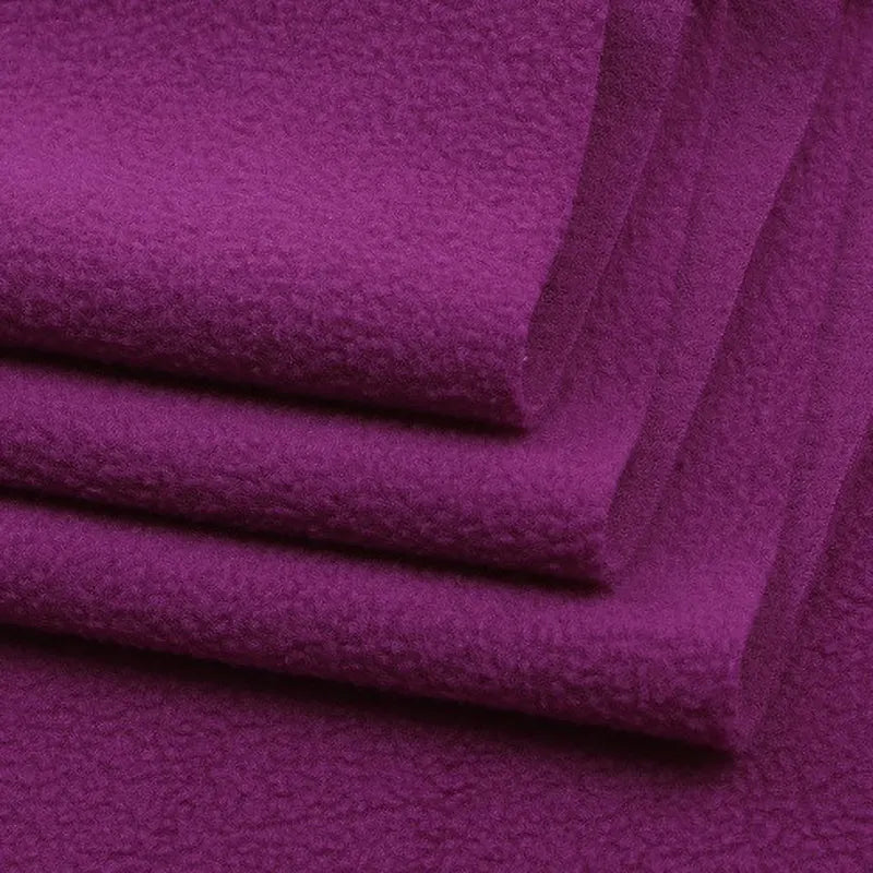 Close-up of three folded pieces of Longon Craft Solid Polar Fleece Fabric By The Yard in deep purple, highlighting the thick, soft 100% polyester surface—ideal for cozy blankets, upholstery, or DIY sewing projects.