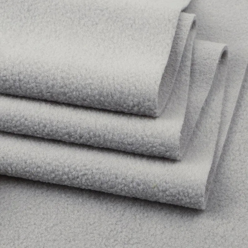 A close-up of folded Longon Craft Solid Polar Fleece Fabric By The Yard highlights its soft, thick 100% polyester texture, ideal for cozy DIY sewing, crafts, or upholstery projects.
