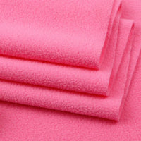 Neatly stacked bright pink Solid Polar Fleece Fabric by Longon Craft shows its thick, soft surface—ideal for cozy blankets or DIY sewing. Buy this 100% polyester material by the yard for your next craft or upholstery project.