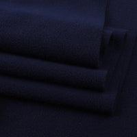 Neatly stacked Solid Polar Fleece Fabric By The Yard from Longon Craft, in dark navy blue. This thick, plain 100% polyester fleece is soft, slightly textured, and ideal for blankets, cozy DIY sewing crafts, and upholstery projects.