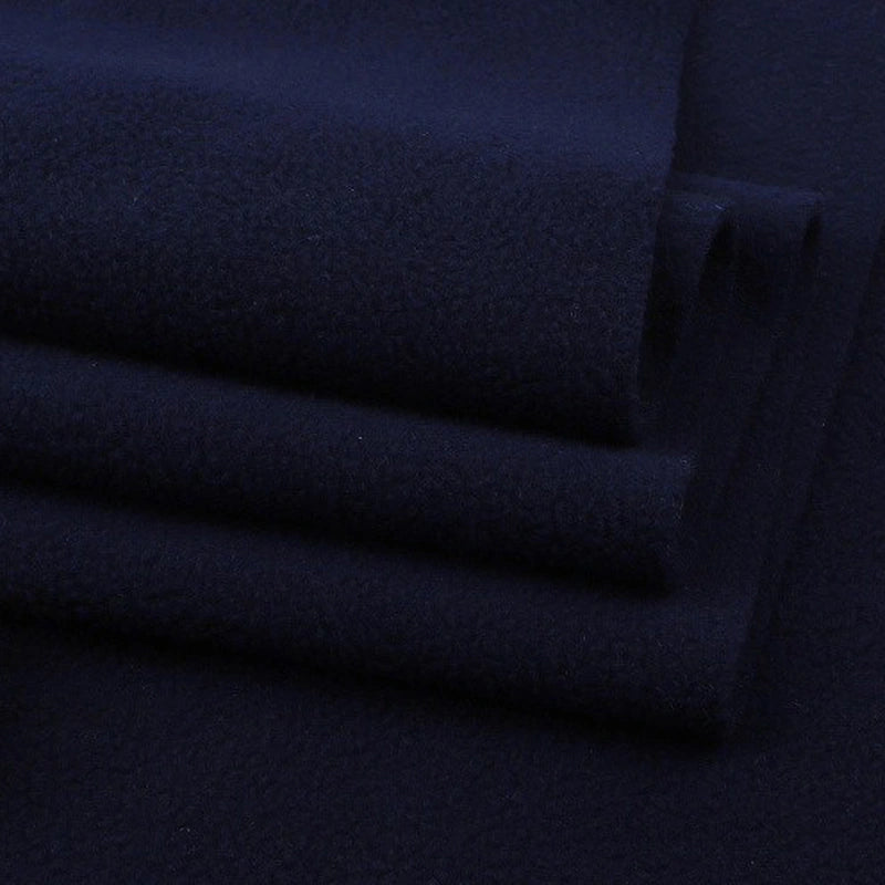 Neatly stacked Solid Polar Fleece Fabric By The Yard from Longon Craft, in dark navy blue. This thick, plain 100% polyester fleece is soft, slightly textured, and ideal for blankets, cozy DIY sewing crafts, and upholstery projects.
