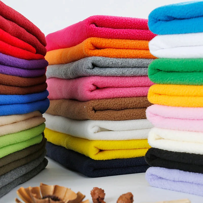 Neatly stacked Solid Polar Fleece Fabric By The Yard from Longon Craft in vibrant colors—red, pink, yellow, green, blue, gray, and white—offers thick 100% polyester material ideal for cozy DIY crafts, blankets, and upholstery projects.