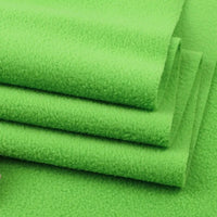A close-up of Longon Craft’s Solid Polar Fleece Fabric by the Yard—thick, bright green 100% polyester perfect for DIY sewing, crafts, upholstery, or cozy blankets—showcasing its soft, textured surface.