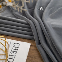 A folded stack of Longon Craft Stretch Minky Fabric By The Yard (Multicolor Four Way Stretch Cuddle) rests on wood beside a magazine and decor, with the number 59 overlaid on the plush material.